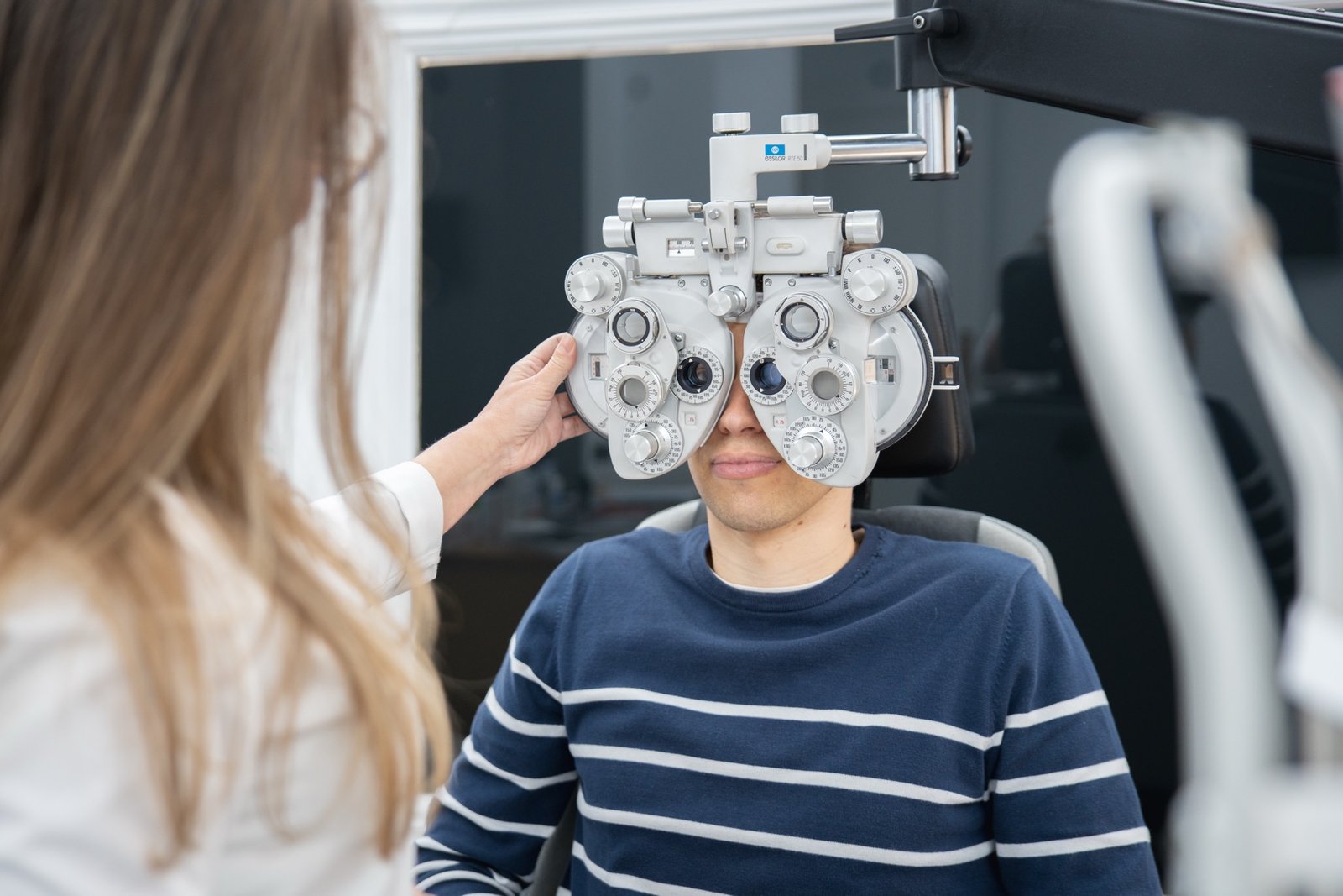 Optometrista de CABA realizando una graduación con foróptero a un paciente